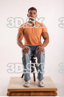 Sitting pose orange thsirt light blue jeans of bodybuilder Harold…